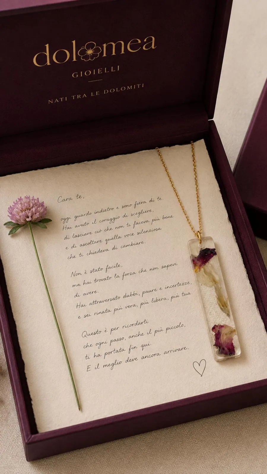 Cofanetto bordeaux aperto con lettera manoscritta e collana a barra