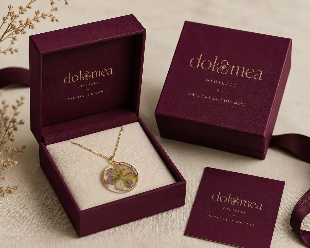 Due cofanetti bordeaux Dolomea con logo in oro e collana tonda a fiori