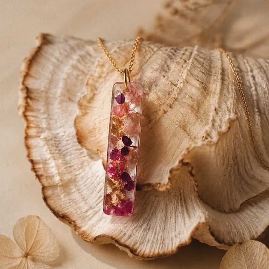 Collana Lilia: ciondolo a barra con petali rosa e foglia oro, su un fungo essiccato